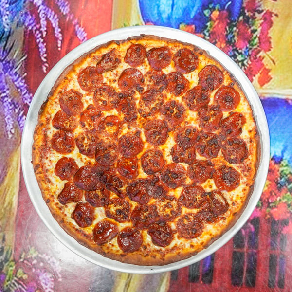 A large, round pepperoni pizza from ELE PIZZA, with a crispy crust and melted cheese, on a colorful table.